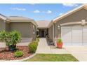 Beautifully landscaped walkway to the front door in this home with neutral tones at 13495 Se 93Rd Court Rd, Summerfield, FL 34491