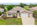 Inviting home features a manicured lawn, tasteful landscaping, and a spacious driveway leading to a garage at 13495 Se 93Rd Court Rd, Summerfield, FL 34491