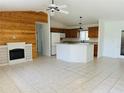 Bright living room featuring a wood accent wall and an electric fireplace and tile flooring at 14117 Sw 115Th Cir, Dunnellon, FL 34432