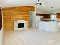 Bright open living room features a wood accent wall and fireplace, opening to the eat-in kitchen at 14117 Sw 115Th Cir, Dunnellon, FL 34432