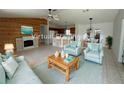 Bright open-concept living room with wood-paneled wall, fireplace, and adjoining kitchen and dining area at 14117 Sw 115Th Cir, Dunnellon, FL 34432