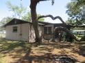 Home exterior with a brown roof, mature tree with thick branches, and multiple windows at 1675 Se 190Th Ave, Silver Springs, FL 34488