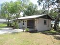 Side view of a single-story home with a brown garage door and mature trees in the yard at 1675 Se 190Th Ave, Silver Springs, FL 34488