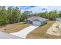 Beautiful exterior view of a gray single-Gathering home, surrounded by lush greenery, features a long driveway at 400 Mariion Oaks Crse, Ocala, FL 34473
