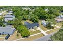 Aerial view of a home with a dark metal roof surrounded by lush greenery in a residential neighborhood at 4095 Sw 144Th St, Ocala, FL 34473