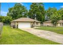 Charming single story home featuring a fenced front yard, attached garage, and long driveway at 5263 Nw 62Nd Nw Ave, Ocala, FL 34482