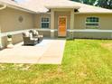Inviting front porch with outdoor seating, beautiful landscaping, and a vibrant orange front door at 5263 Nw 62Nd Nw Ave, Ocala, FL 34482