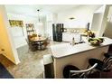 Bright kitchen with white cabinets, stainless steel appliances, and a cozy dining area at 5263 Nw 62Nd Nw Ave, Ocala, FL 34482