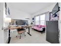 Bright flex room includes neutral decor, a futon, desk, and monitor setup at 5621 Sw 90Th Ln, Ocala, FL 34476