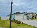 This blue home features a two-car garage and well-maintained landscaping, located on a spacious lot at 5667 Sw 92Nd Pl, Ocala, FL 34476