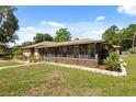 Spacious backyard with a screened-in patio, garden, and lush green lawn at 6157 Ne 25Th Ave, Ocala, FL 34479