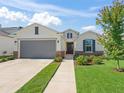 Charming home featuring stone accents, a grey garage door, and a landscaped lawn at 7206 Sw 60Th Ln, Ocala, FL 34474