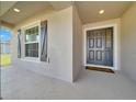 Inviting front porch featuring a stylish gray front door and sleek exterior finish at 8943 Se 41St Court Rd, Ocala, FL 34480
