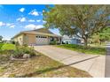 Well-maintained single-story home featuring a long driveway and a green lawn at 9750 Sw 97Th Pl, Ocala, FL 34481