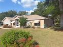 The exterior showcases a well-maintained lawn, mature trees, and meticulously landscaped flower beds around the residence at 1001 Ne 22Nd Ave, Ocala, FL 34470