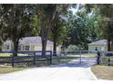 Charming home featuring a gated entrance, lush landscaping, and a detached garage at 10208 Se 170 Pl, Summerfield, FL 34491