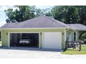 A two car garage with a white door is connected to the home, with a white car inside at 10208 Se 170 Pl, Summerfield, FL 34491