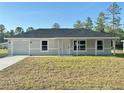 Lovely one-story home featuring a neutral color scheme, attached garage, and a lush green front yard at 14425 Sw 21St Pl, Ocala, FL 34481