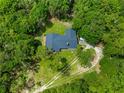 Aerial shot of the property featuring a house nestled amongst mature trees and lush greenery at 17150 Se 168Th Ter, Weirsdale, FL 32195