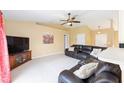 Spacious living room featuring vaulted ceilings, plush leather seating, and a ceiling fan at 2 Hemlock Trace Run, Ocala, FL 34472