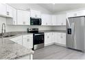 Modern kitchen featuring stainless steel appliances, white cabinets, and elegant granite countertops at 22777 Sw Beach Blvd, Dunnellon, FL 34431