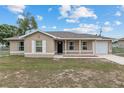 Inviting single-story home with a covered porch, neutral-toned exterior, white-trimmed windows, and an attached garage at 2690 Sw 154Th Ln, Ocala, FL 34473