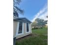Side view of home with board and batten and large windows overlooking green lawn and mature trees at 3005 Ne 19Th Ave, Ocala, FL 34479