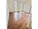 Bright living room featuring wood-look flooring, white walls, and sun-drenched windows at 3005 Ne 19Th Ave, Ocala, FL 34479