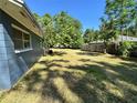 Large backyard with green grass and shady trees offers ample space for outdoor activities at 4000 Sw 6Th Ave, Ocala, FL 34471