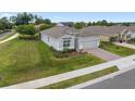 Inviting single-story home with lush green lawn, mature landscaping, and a brick driveway at 4892 Nw 39Th Loop, Ocala, FL 34482