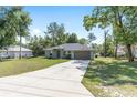 Charming single-story home with an expansive front lawn, long driveway, and attached two-car garage at 5425 Pecan Rd, Ocala, FL 34472