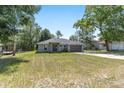 Well-maintained single-story home with a two-car garage and front lawn surrounded by mature trees at 5425 Pecan Rd, Ocala, FL 34472