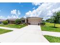 Inviting single-story home featuring a spacious driveway, manicured lawn, and colorful landscaping at 6265 Sw 88Th Loop, Ocala, FL 34476