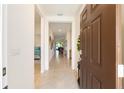 Open foyer with tile flooring leading into a well-lit home and view into a bedroom at 6265 Sw 88Th Loop, Ocala, FL 34476