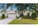 Attractive single-story house showcasing a 2-car garage, lush lawn, and a beautifully landscaped front yard at 7263 Sw 99Th Cir, Ocala, FL 34481