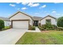 Lovely single-story residence with a two-car garage, manicured lawn, and an inviting facade at 7263 Sw 99Th Cir, Ocala, FL 34481