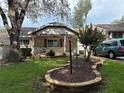 Well-manicured front yard featuring a charming brick planter, mature trees, and classic exterior at 9801 Sw 88Th Ter # B, Ocala, FL 34481