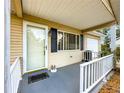Inviting front porch with white railings, a storm door, and classic exterior lighting at 10520 Sw 85Th Ter, Ocala, FL 34481