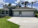 Charming single-story home with well-manicured lawn and a three-car garage on a sunny day at 10540 Sw 49Th Avenue Rd, Ocala, FL 34476