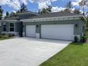 Modern home with a three-car garage, featuring manicured landscaping and a spacious driveway at 10540 Sw 49Th Avenue Rd, Ocala, FL 34476