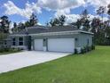 Side view of a modern home with a large three-car garage and well-maintained landscaping at 10540 Sw 49Th Avenue Rd, Ocala, FL 34476