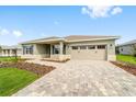 The exterior of this home showcases a paver driveway and a front lawn with mulch at 10625 Sw 98Th Pl, Ocala, FL 34481