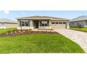 One-story home with a well-manicured lawn, paver driveway, and a two-car garage at 10625 Sw 98Th Pl, Ocala, FL 34481