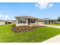 Landscaped front yard leading up to this beautiful home with an attached two car garage at 10625 Sw 98Th Pl, Ocala, FL 34481