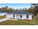 Charming single-Gathering home with a well-manicured lawn, fresh landscaping, and a one car garage with a driveway at 11200 Sw 131 Ter, Dunnellon, FL 34432