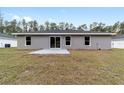 A spacious backyard with a concrete patio and lush green grass at 13568 Sw 109 Ln, Dunnellon, FL 34432