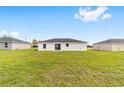 Expansive green backyard with a simple, modern home featuring a sliding glass door at 15424 Sw 27 Ln, Ocala, FL 34481