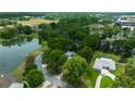 An aerial view showcases this home's setting near a pond, mature trees, and spacious green areas at 1628 Se 29Th Ter, Ocala, FL 34471