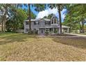 A beautiful two-story home with gray siding, a porch, and a well-manicured yard sits among the trees at 1628 Se 29Th Ter, Ocala, FL 34471
