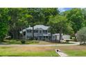 A two-story home with blue siding sits amongst the trees at 1628 Se 29Th Ter, Ocala, FL 34471